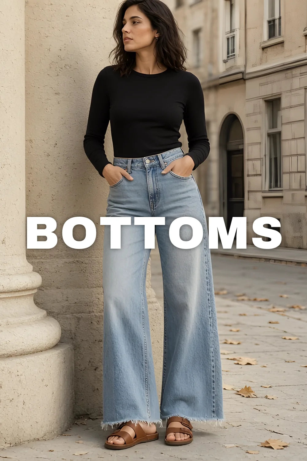 Bottoms — woman in light blue wide-leg jeans and a black long-sleeve top beside a stone column